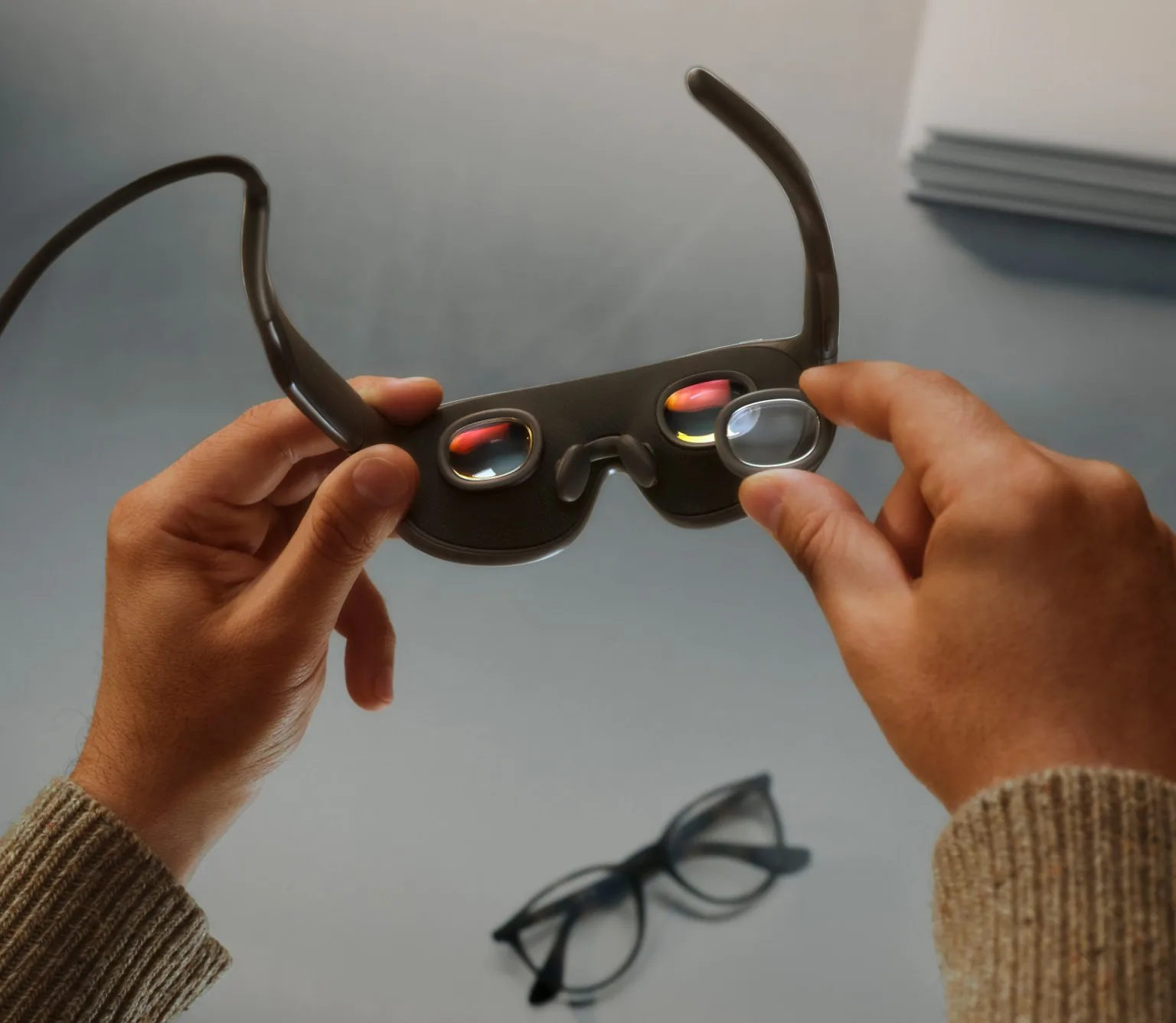 Hands holding Meta VR Glasses from the inside, showing two small lenses, the nose pads and a prescription insert being fitted