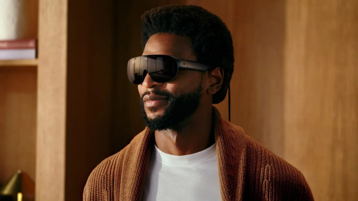 A man wearing Meta VR Glasses, which look like a pair of dark wraparound sunglasses